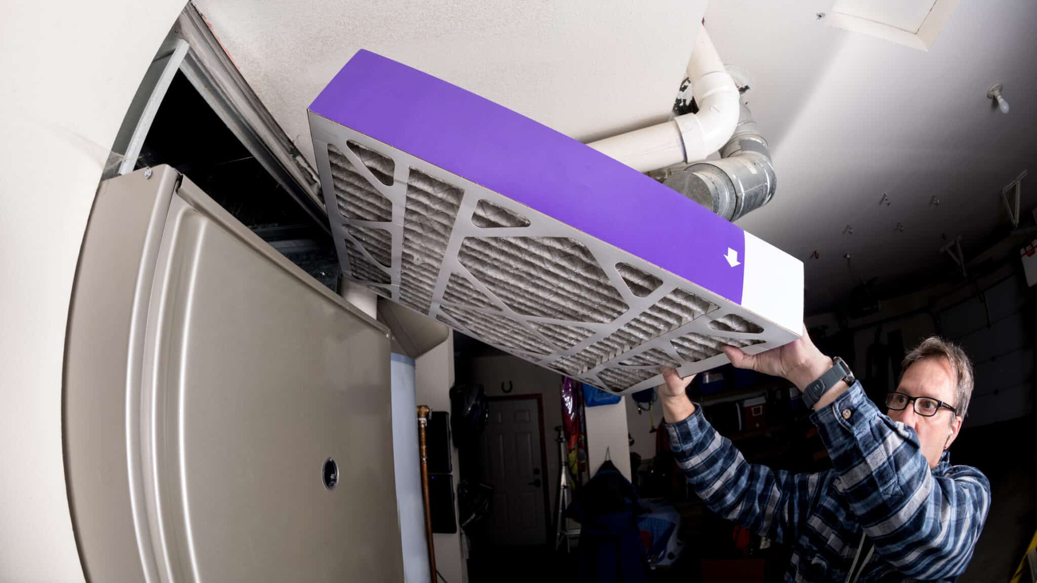 HVAC Technician Inserts a New Furnace Filter.