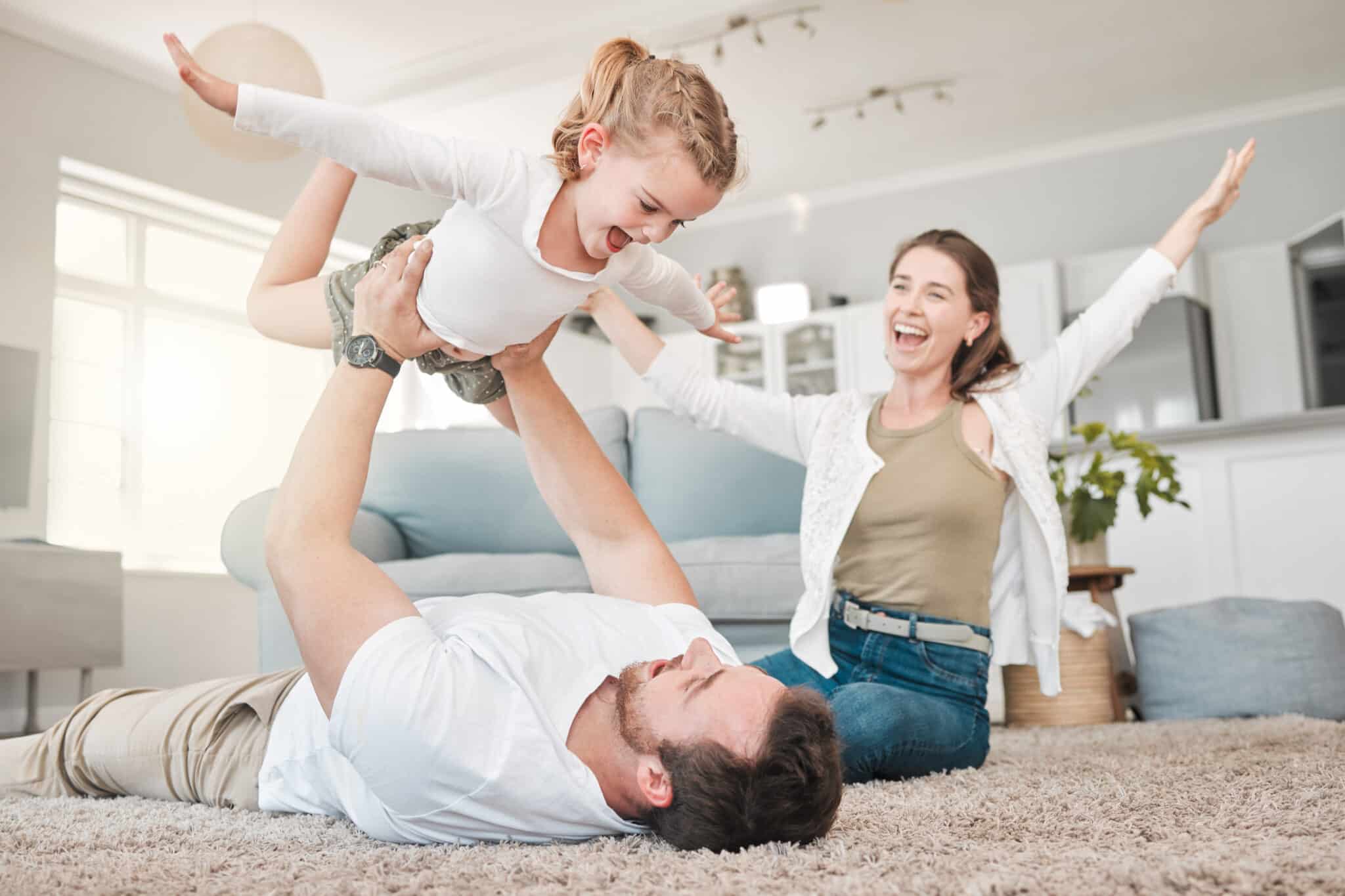 Father and daughter bonding while playing on the floor at home, Mini Split AC.