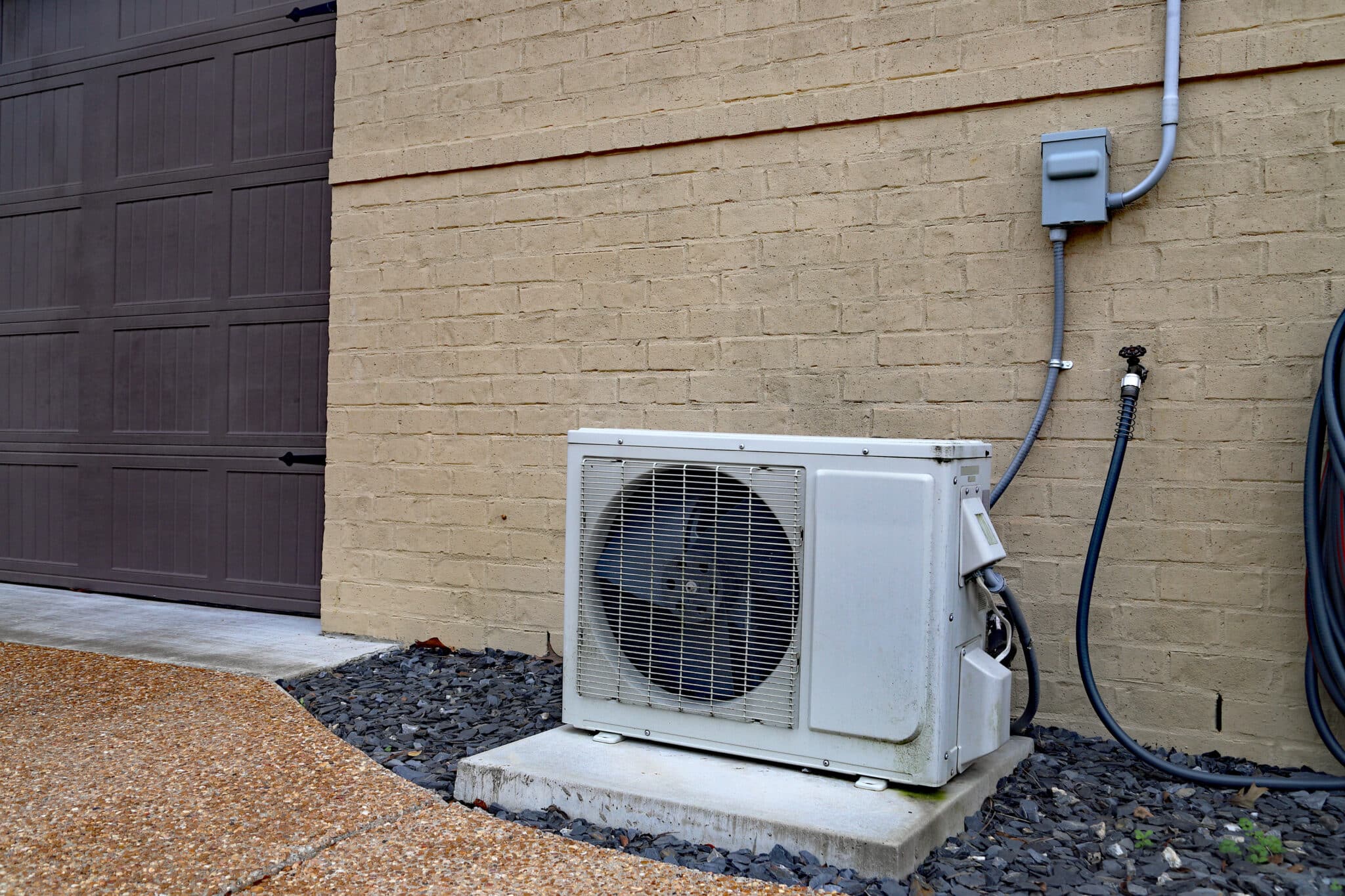 Air Conditioner mini split system next to home with brick wall, Mini Split AC.